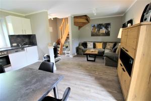 a kitchen and living room with a couch and a table at Rosen-Haus in Fehmarn