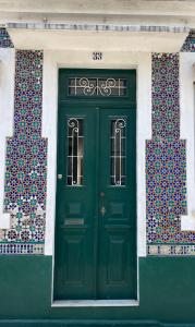 una puerta verde al lado de un edificio en Casa da Genoveva - Typical House, en Aveiro