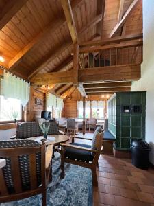 a living room with wooden ceilings and a table and chairs at Haus Uhlennest in Ühlingen-Birkendorf