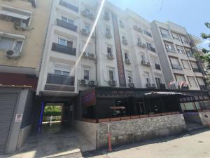 un grand bâtiment blanc avec une façade de magasin dans l'établissement SKY HOTEL & APARTMENTS, à Antalya