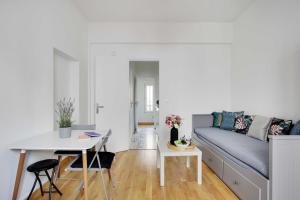 ein Wohnzimmer mit einem Sofa und einem Tisch in der Unterkunft Amazing studio 2P near Paris et La Défense in Levallois-Perret
