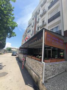 un magasin à l'avant d'un bâtiment muni d'un panneau. dans l'établissement SKY HOTEL & APARTMENTS, à Antalya