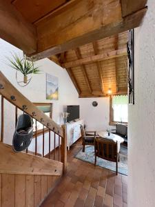 a living room with wooden ceilings and a staircase at Haus Uhlennest in Ühlingen-Birkendorf