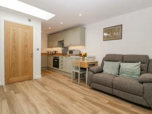 a living room with a couch and a kitchen at Barrow Lodge in Blandford Forum