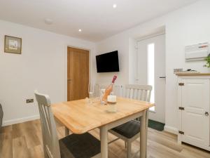 a dining room with a wooden table and chairs at Barrow Lodge in Blandford Forum