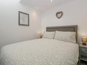 a bedroom with a bed and a mirror on the wall at Barrow Lodge in Blandford Forum