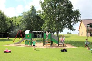 un grupo de niños jugando en un parque infantil en Teichhauswohnung, en Fehmarn