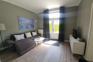 Una sala de estar con un sofá y un televisor. en Untere Teichwohnung, en Fehmarn 12 fotos más