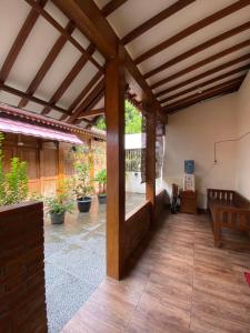Elle comprend une grande terrasse dotée d'un plafond en bois et de parquet. dans l'établissement Jogja Classic Homestay Syariah, à Yogyakarta