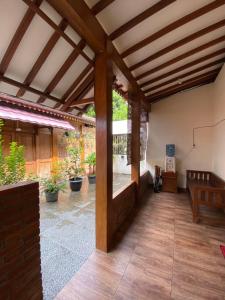 een grote patio met een houten plafond en houten vloeren bij Jogja Classic Homestay Syariah in Yogyakarta