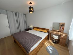 1 dormitorio con cama, escritorio y espejo en Wohnung auf dem Bürgenstock, en Kehrsiten