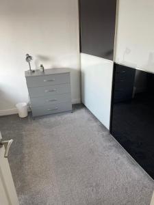 une pièce vide avec une commode et un miroir dans l'établissement 3 Bed Sleep 6, Bootle/Aintree, à Bootle