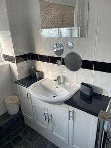 a bathroom with a sink and a mirror at 3 Bed Sleep 6, Bootle/Aintree in Bootle