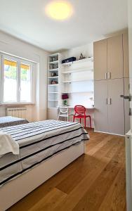 a bedroom with a large bed and a red chair at Dorico Apartment in Ancona