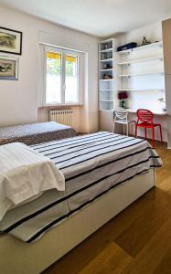 a bedroom with a large bed and a red chair at Dorico Apartment in Ancona