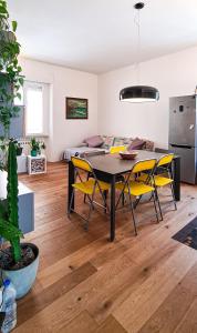 a living room with a dining room table and yellow chairs at Dorico Apartment in Ancona