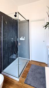 a bathroom with a glass shower with a sink at Dorico Apartment in Ancona