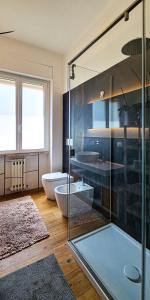 a bathroom with a glass shower and a tub at Dorico Apartment in Ancona