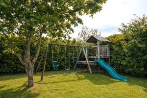 a playground with a slide and a swing at Poyers Farmhouse in Wrafton
