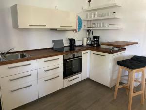 a kitchen with white cabinets and a stove top oven at Ferienwohnung am Friedenspark 2 in Thale