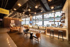 a restaurant with a bar with chairs and tables at ibis Styles Sarajevo in Sarajevo