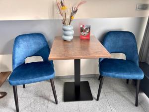 ブルージュにあるB&B Contrastの青い椅子2脚付きテーブル