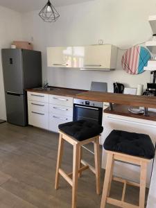 a kitchen with a counter and two stools in it at Ferienwohnung am Friedenspark 2 in Thale