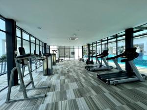 a gym with treadmills and machines in a building at Cozy Couple Suite at Trefoil Setia Alam in Shah Alam