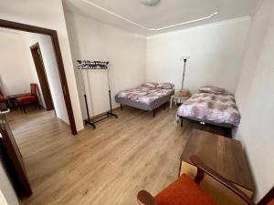 um quarto com duas camas e uma mesa em Home Base Apartments em Skopje