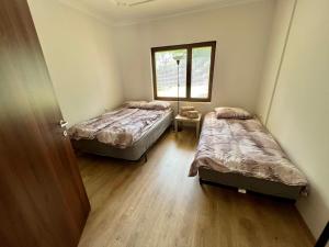 a room with two beds and a window at Home Base Apartments in Skopje