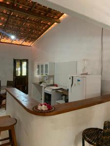 a kitchen with a counter and a white refrigerator at Casa Branca in Atins