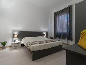 a bedroom with a large bed and two windows at Le Montagne - Le Casette di Osvaldo in Lecco
