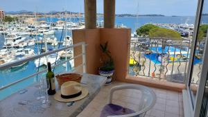 Apartment Hirondelle Port Frejus في فريجوس: طاولة مع زجاجة من النبيذ على شرفة مع مارينا