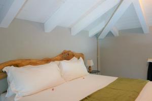1 dormitorio con 1 cama grande con almohadas blancas en Capriccio Art Hotel, en Serravalle Scrivia