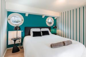 1 dormitorio con 1 cama blanca grande y paredes azules en Péniche de prestige à Namur avec vue sur la Citadelle - A l'Abordage - By Voyages Copine en Namur
