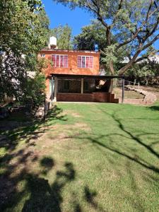 Una casa con un gran patio al frente. en Complejo Los Manantiales, en Alta Gracia