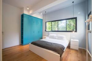 a bedroom with a large bed with blue cabinets at TLV beach 4 rooms big balcony / 125 m2 appart in Tel Aviv