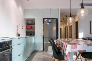 a kitchen with a table with chairs and a refrigerator at TLV beach 4 rooms big balcony / 125 m2 appart in Tel Aviv