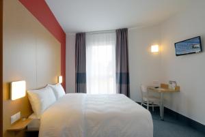 um quarto de hotel com uma cama grande e uma secretária em B&B Hotel Prague City em Praga