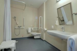 W łazience znajduje się umywalka, toaleta i lustro. w obiekcie B&B Hotel Prague City w Pradze
