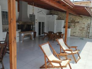 a patio with rocking chairs and a fireplace at Apartment Ioanna #2 in Kallithea Halkidikis