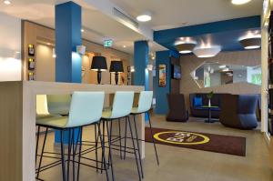 a bar in a dental office with blue walls and stools at B&B Hotel Paderborn in Paderborn