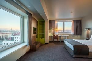 ノヴィ・タルクにあるB&B Hotel Nowy Targ Centrumのベッド、デスク、窓が備わるホテルルームです。