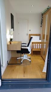 London Anayah apartments في لندن: غرفة بها مكتب وكرسي وسرير