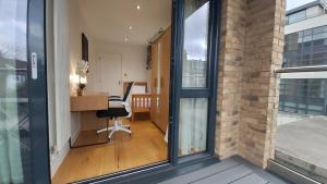 an office with a desk and a chair next to a window at London Anayah apartments in London