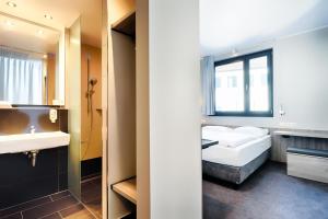 1 dormitorio con cama, lavabo y espejo en B&B Hotel Nürnberg-Plärrer en Núremberg