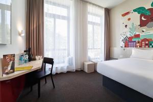 Cette chambre comprend un lit, un bureau et une fenêtre. dans l'établissement B&B Hotel Poznań Old Town, à Poznań