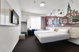 pokój hotelowy z dwoma łóżkami i telewizorem w obiekcie B&B Hotel Poznań Old Town w Poznaniu