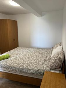 a small bed in a room with a wooden cabinet at Apartments Linic in Nin