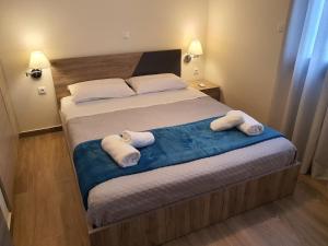 een slaapkamer met een bed met handdoeken erop bij Island View Apartments in Moúdhros